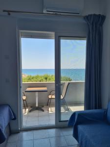 Habitación con vistas al océano a través de una puerta corredera de cristal. en Lyttos, en Tsoutsouros