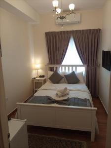 a bedroom with a white bed with a window at The Boutique Hotel Amman in Amman