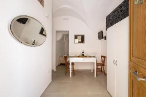 einen Flur mit einem Tisch und einem Spiegel an der Wand in der Unterkunft Vico dei Mille by BarbarHouse in Tuglie