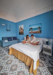 a man and a woman sitting on a bed at La Bifora e il granaio in Sciacca +61 photos