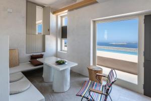 Habitación con mesa, silla y ventana en Serra Exclusive Suites en Akrotiri