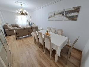 uma sala de jantar com uma mesa branca e cadeiras em Apartamento de 120m2 al lado de Cabarceno em Sarón