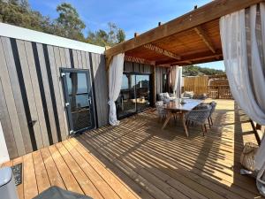 una terraza de madera con mesa y sillas. en Mobile home grand confort 3 chambres neuf en Saint-Raphaël