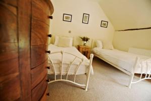a bedroom with two beds and a dresser at White Horse Cottage with Sauna in Ollerton