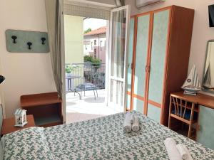 a bedroom with a bed and a door to a balcony at HOTEL BLUE SKY in Rimini