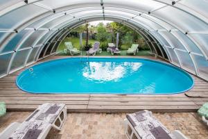 - une grande piscine dans un bâtiment en forme de dôme avec des chaises dans l'établissement Casa Arcadia Buzau Monteoru, à Buzău