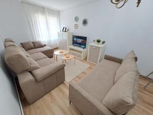 un soggiorno con divano e TV di Apartamento de 120m2 al lado de Cabarceno a Sarón