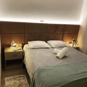 a bedroom with a large bed with a large headboard at Excelente apartamento em Gramado/RS no Condomínio Casa de Pedra in Gramado