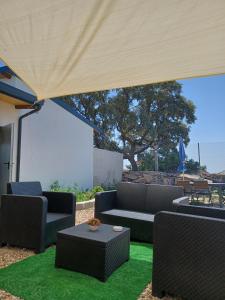 a patio with couches and a table on green grass at Bungalow Sierra San Vicente in Hinojosa de San Vicente