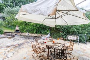 a patio with a table and an umbrella at Quercia Close By to Montepulciano - Happy Rentals in Montepulciano