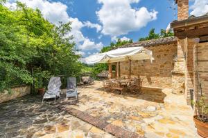 a patio with a table and chairs and an umbrella at Quercia Close By to Montepulciano - Happy Rentals in Montepulciano