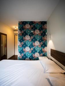 um quarto com uma cama grande e uma parede floral em Hotel Grand Cap Rooftop Pool em Agde