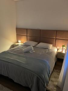 a bedroom with a large bed with two pillows at Excelente apartamento em Gramado/RS no Condomínio Casa de Pedra in Gramado