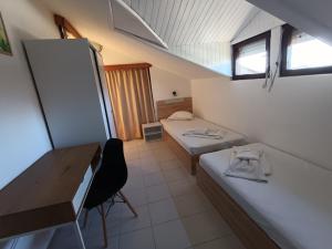 a small room with two beds and a desk at Ianakiev Guest House in Chernomorets