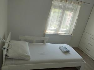 a white bed in a room with a window at Misljen apartmants in Zadar