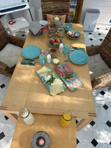 einem Holztisch mit Teller mit Lebensmitteln darauf in der Unterkunft Tolles Apartment in idyllischer ruhiger Lage in Braunschweig