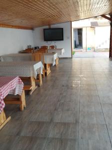 comedor con mesas y TV de pantalla plana en Pensiunea Krystinne, en Hunedoara