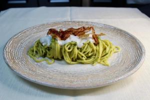 a plate of pasta with bacon on a table at Masseria Monte Pizzi Glamping Dome in Cerreto