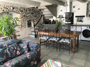 salon z kanapą i stołem z krzesłami w obiekcie Charmant gîte entre vallée de la Rance et côte d'Emeraude w mieście Pleslin-Trigavou
