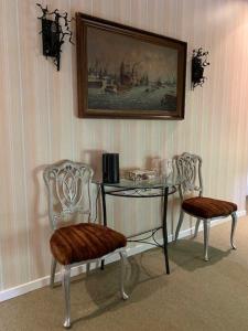 stół i dwa krzesła ze stołem i obrazem w obiekcie Domaine la Cabane w mieście Dégagnac