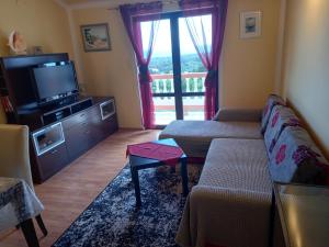 a living room with a couch and a television at Apartman Jadranka in Rab