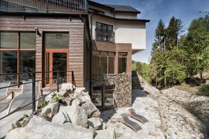 a house on a hill with rocks in front of it at Hotel Żywiecki Medical SPA & Sport Żywiec in Żywiec