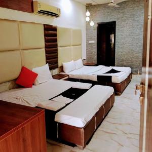 een kamer met drie bedden in een kamer bij HOTEL WELCOME in Surat