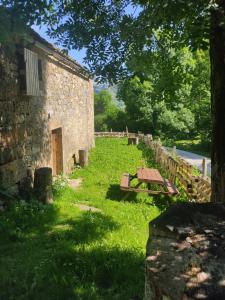 un edificio in pietra con un tavolo da picnic nell'erba di Loma Bonita a Valdició