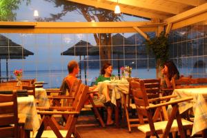 a group of people sitting at a table in a restaurant at Hotel Grand Nefeli in Vasiliki
