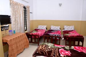 um quarto com quatro cadeiras, uma mesa e uma televisão em AC MIST em Munnar