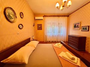 um quarto com uma cama, uma cómoda e uma janela em Apartman Cinthia em Crikvenica