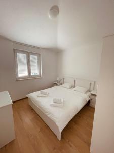 a white bedroom with a white bed and a window at White Truffle Pula in Marčana