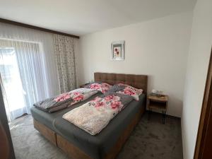 a bedroom with a large bed with flowers on it at Haus Stofleth in Tschagguns +5 photos