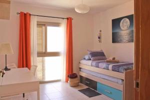 ein Schlafzimmer mit Bett, Schreibtisch und Fenster in der Unterkunft Casa Camille Vista al Mar in Costa de Antigua