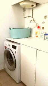 eine Waschmaschine mit einem blauen Korb darauf in der Unterkunft Casa Camille Vista al Mar in Costa de Antigua