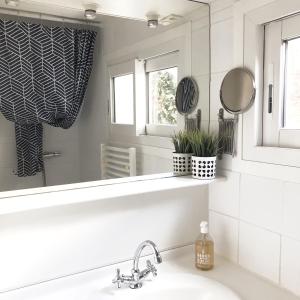 a bathroom with a sink and a mirror at Charmante maison entre Marché et Tourelles in Pornichet