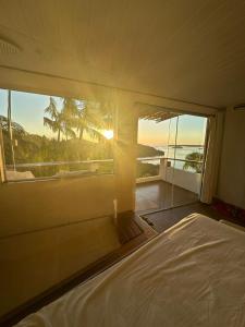 a bedroom with a bed and a view of the ocean at Toca da Tulipa in Paraty