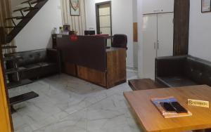 ein Wohnzimmer mit einem Schreibtisch und einem Tisch in der Unterkunft HOTEL WELCOME in Surat
