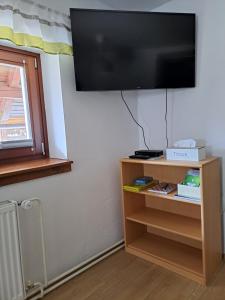 a flat screen tv hanging on a wall next to a window at Apartments Pr'Krštano in Kranjska Gora