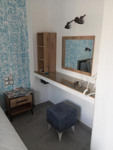 a bedroom with a desk and a blue ottoman at Perivoli Tessas' in Parga