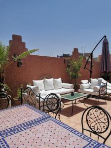 a patio with a couch and chairs and tables at Dar Al Hayat in Marrakech