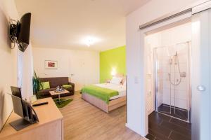 a hotel room with a bed and a bathroom at Café & Wein Gästehaus Kurz in Heilbronn