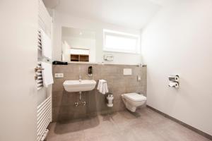La salle de bains est pourvue d'un lavabo et de toilettes. dans l'établissement Café & Wein Gästehaus Kurz, à Heilbronn