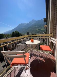 uma mesa e cadeiras numa varanda com montanhas em Studio 55 em Aosta