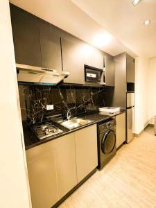 a kitchen with a stove and a washer and dryer at central apartment for rent 30 in Umm Uthainah