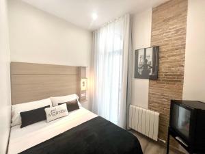 1 dormitorio con 1 cama y TV en Front Arc en Barcelona