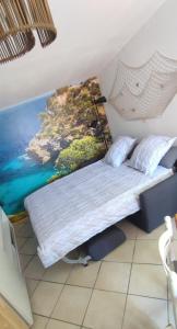 Ce lit se trouve dans un dortoir orné d'une peinture murale. dans l'établissement Studio de la Baie, à Langueux