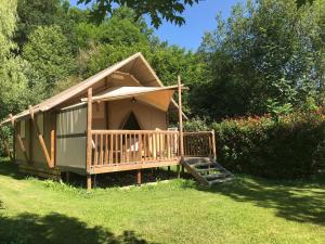 a dog house with a porch in the grass at Camping-Gites Au songe du Valier in Seix