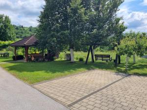 a park with a gazebo and benches and trees at Apartment Rosandić in Smoljanac