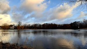 a large lake with a house in the background at Norderbarg in Bredstedt +4 photos